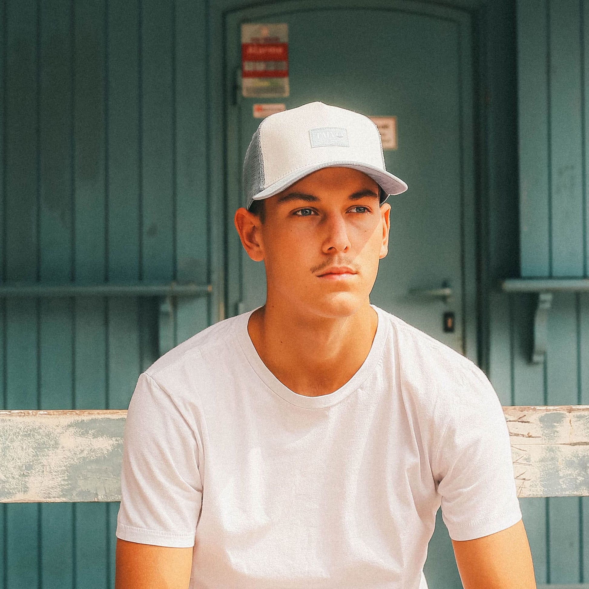 Casquette trucker eco-responsable bleu gris portée par un jeune mannequin