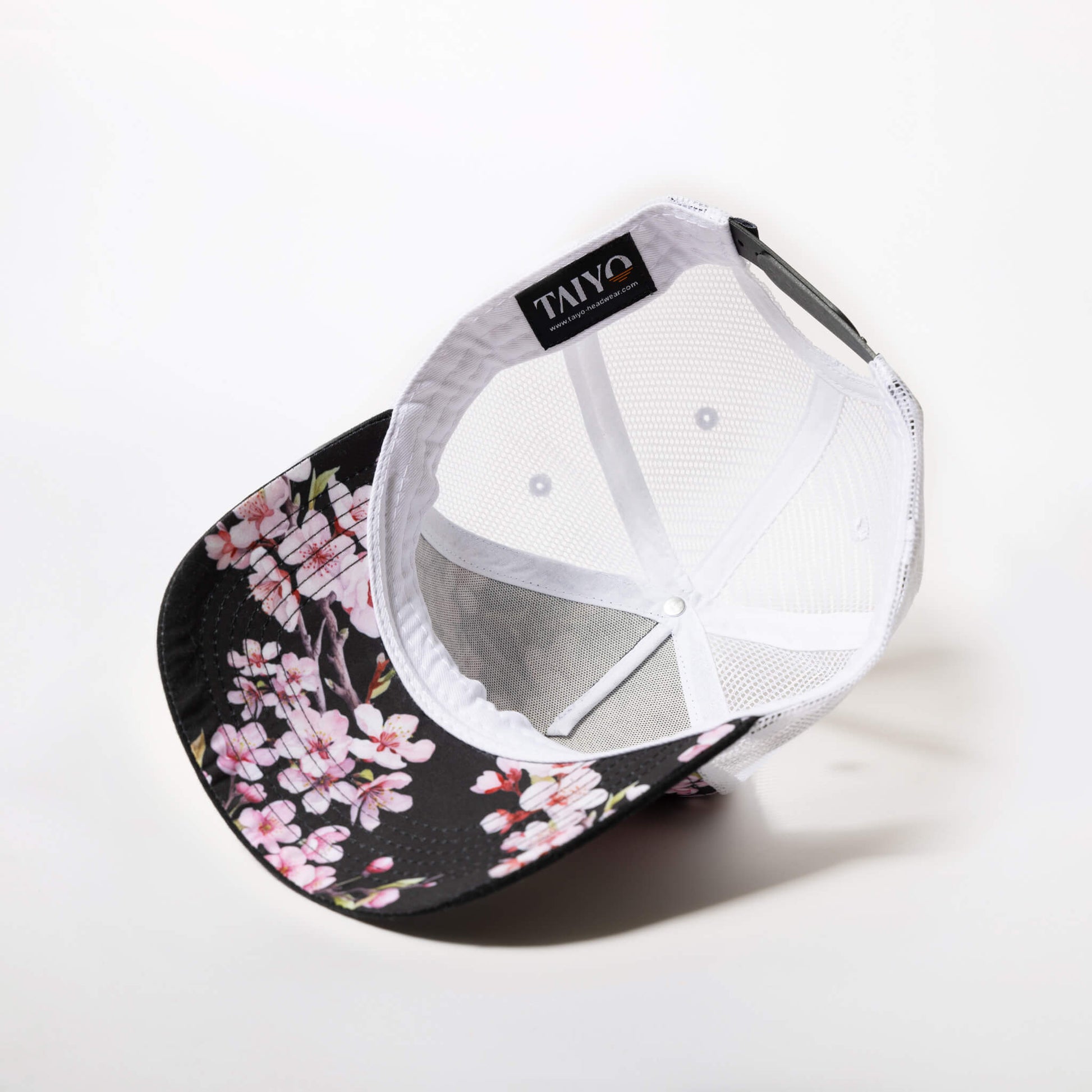 imprimé sakura sous visière d'une casquette trucker noire