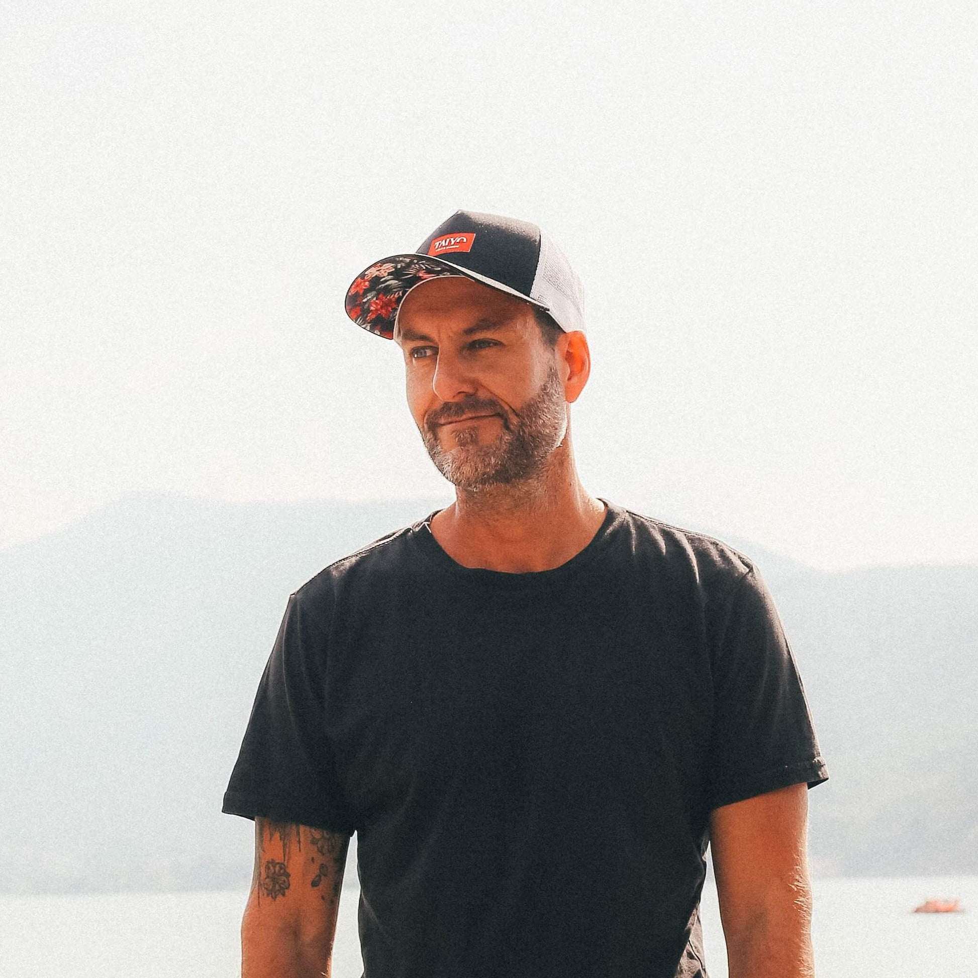 casquette trucker noir avec des fleurs rouges sous la visière