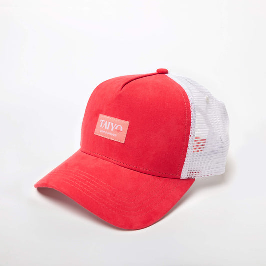 Casquette Sakura Trucker Pink de TAIYO avec panneau avant rose en suède, imprimé floral cerisier sous la visière, maille arrière blanche et patch tissé rose pâle.